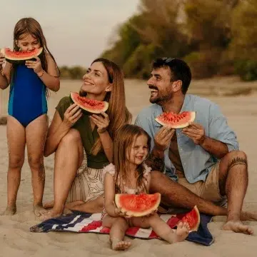 Familienbande 5 Familie am Strand isst Wassermelone